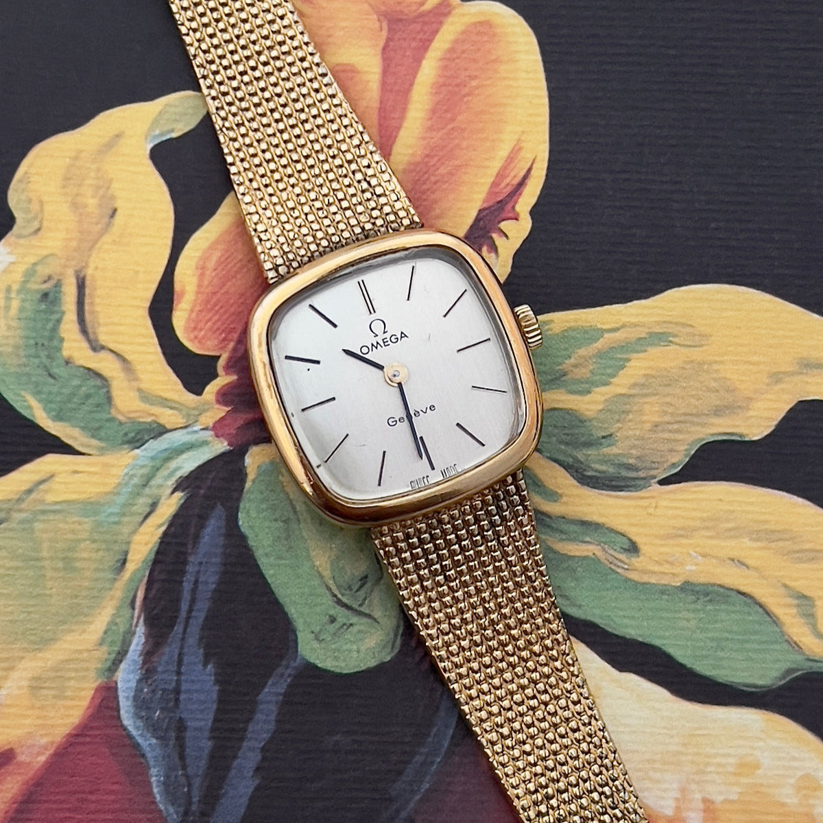 Omega Gold watch with a floral patterned fabric background