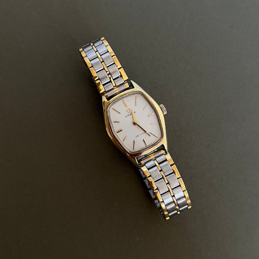 Two-tone Omega watch with gold and silver band on a dark background