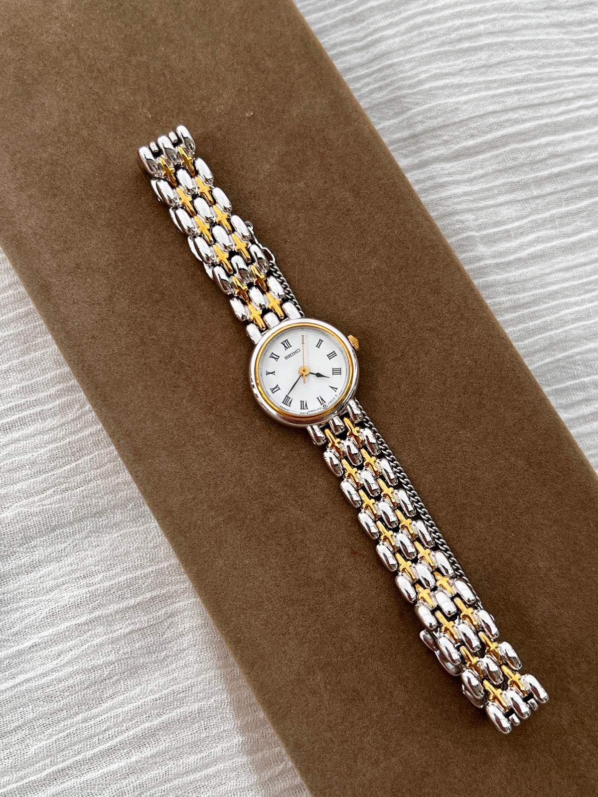 Seiko vintage ladies dress watch with two-tone gold and silver bracelet, white Roman numeral dial, and spade hands – classic quartz timepiece from Gilded Hour NZ.