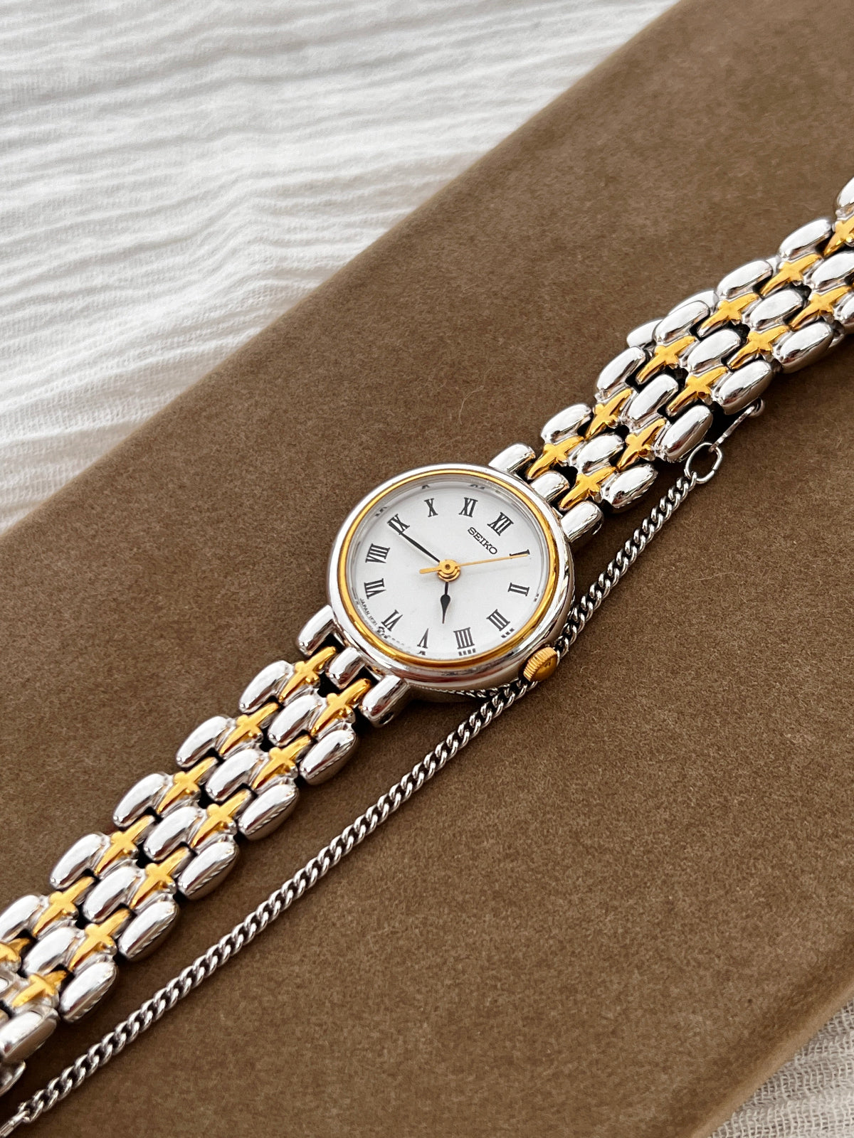 Seiko vintage ladies dress watch with two-tone gold and silver bracelet, white Roman numeral dial, and spade hands – classic quartz timepiece from Gilded Hour NZ.