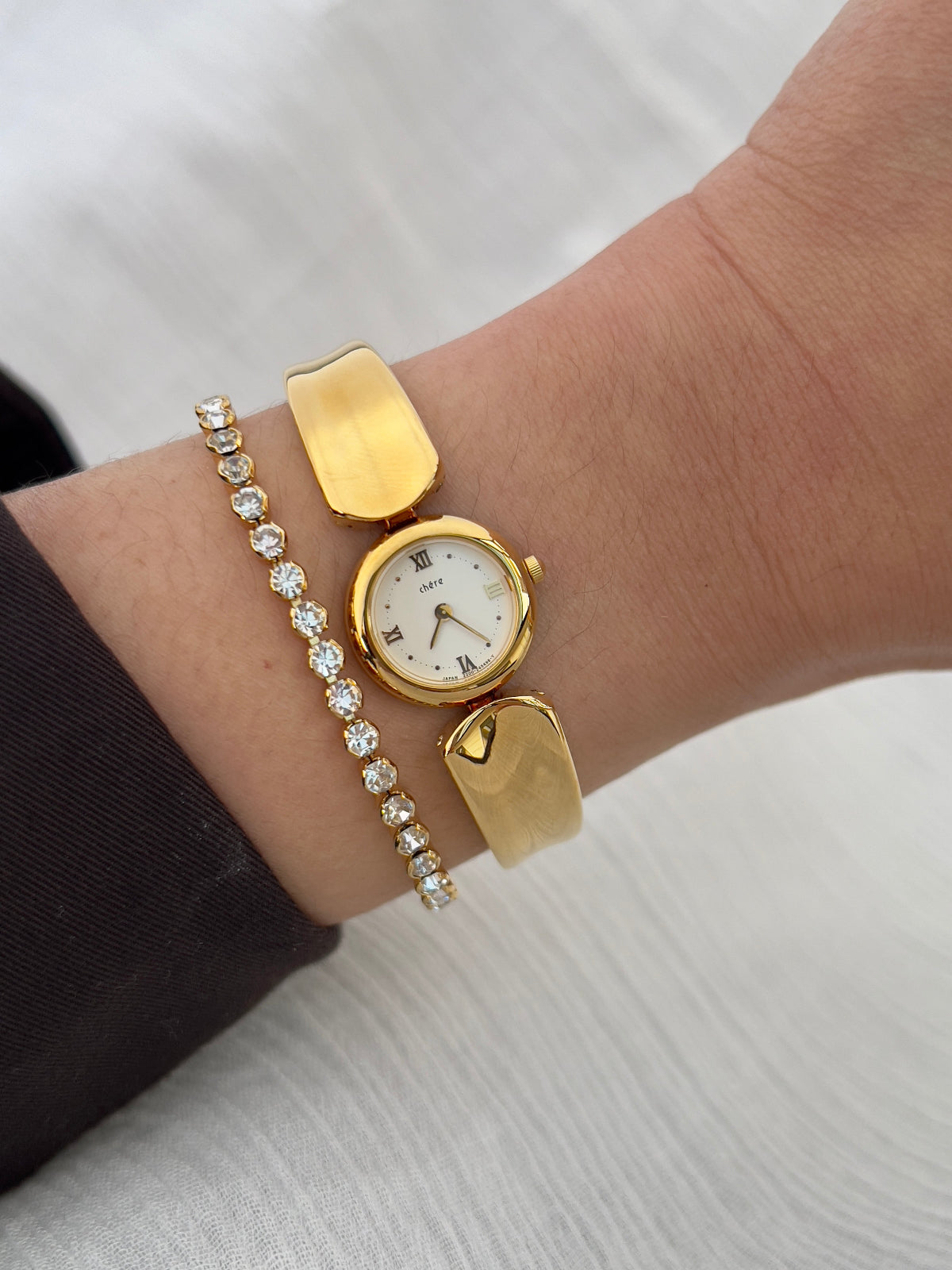 Vintage Citizen Chère women’s gold bangle watch with white dial and Roman numeral, styled on wrist with a crystal tennis bracelet