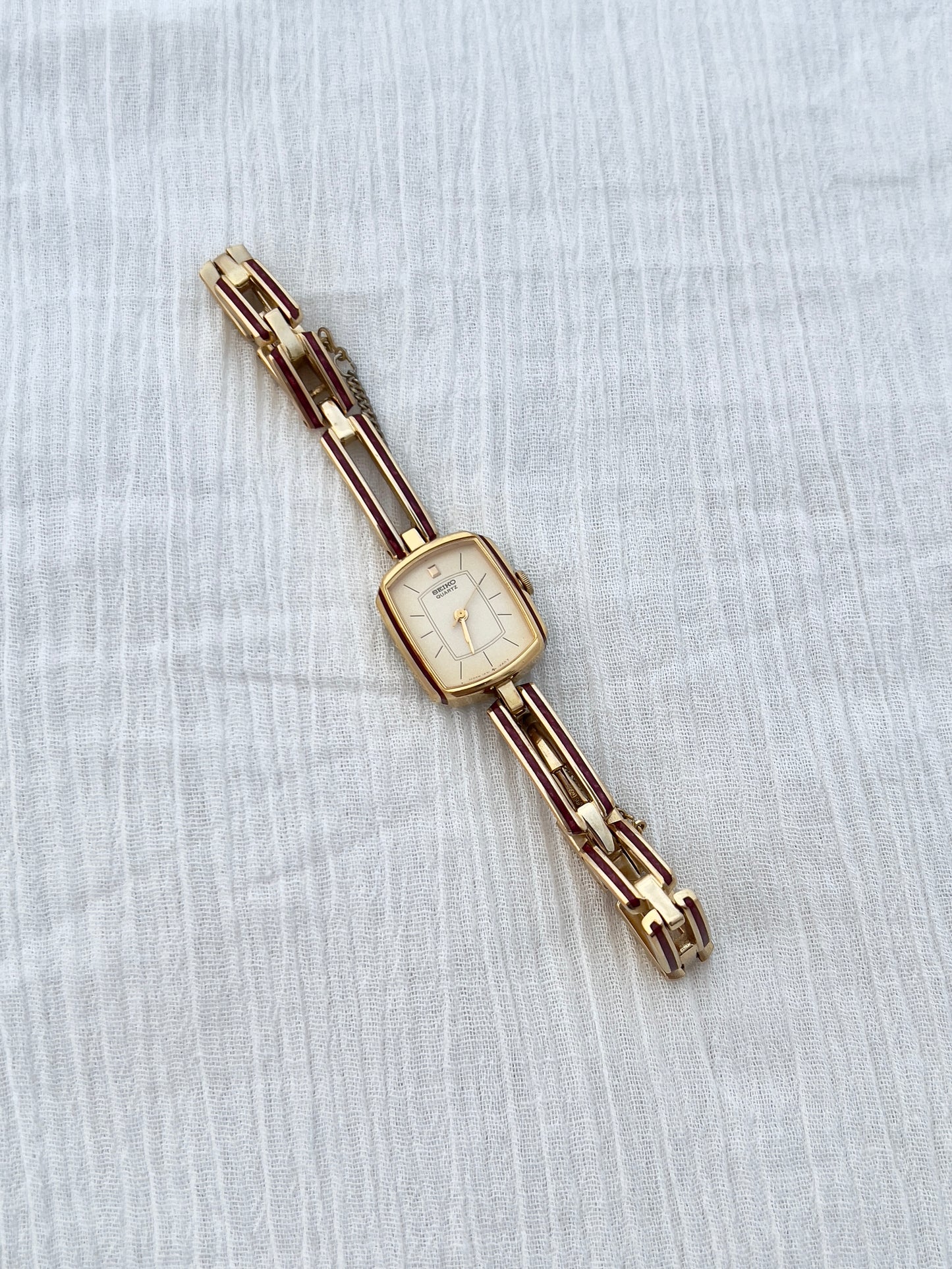 Seiko Ladies Gold Bracelet Watch with Crimson Enamel Accents