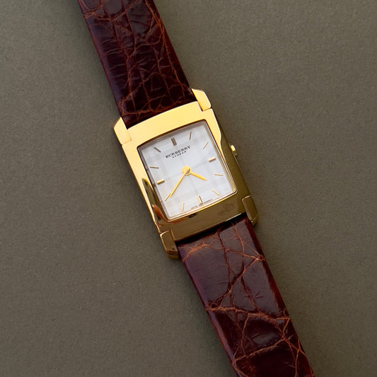 Burberry London rectangular gold ladies watch with white dial and brown croc-embossed leather strap, displayed on neutral background.