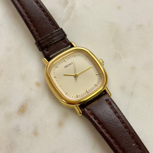 Vintage Seiko watch with brown leather strap on a marble surface