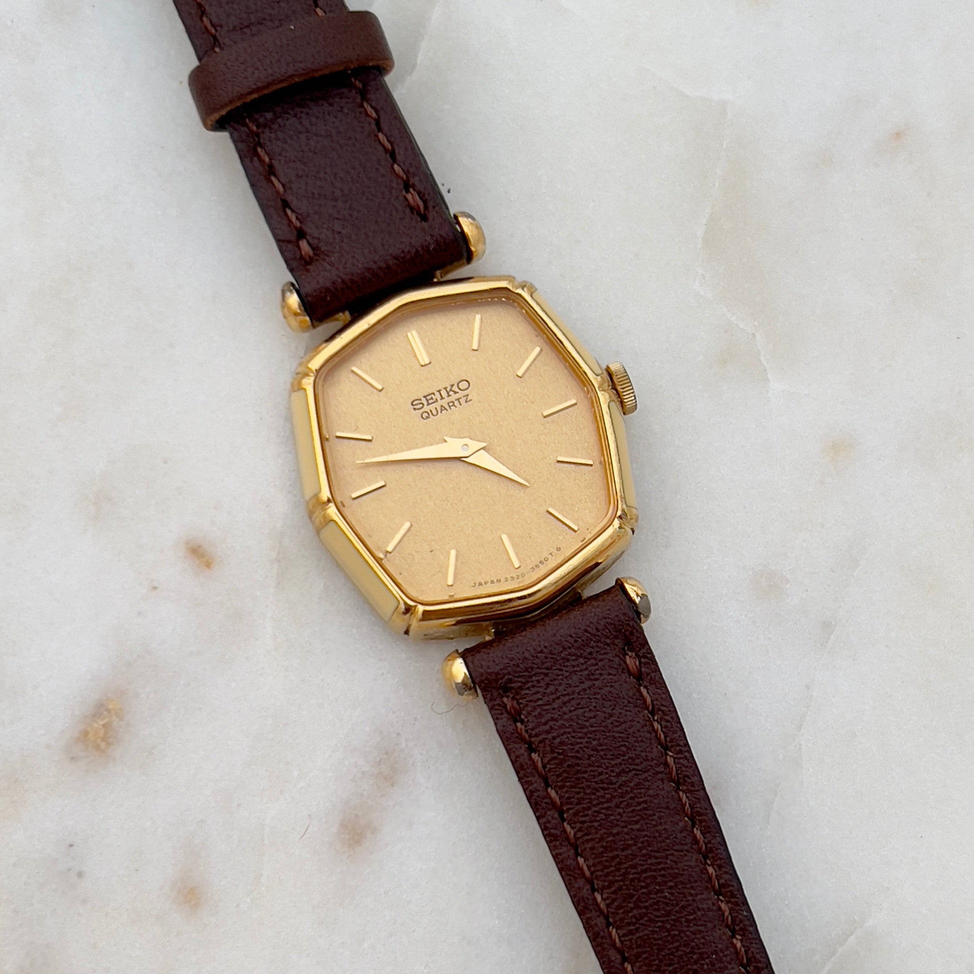 Vintage Seiko watch with brown leather strap on a marble surface