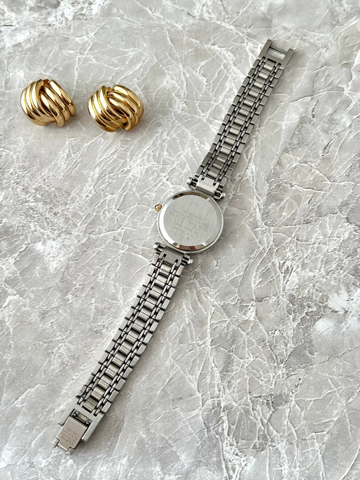 Seiko Exceline Two Tone Roman Dial Watch: caseback with bracelet laid flat.
