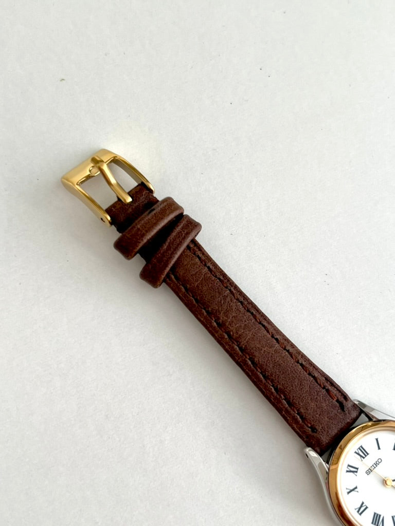 Gold tone pin buckle and two brown leather strap keepers on the Seiko Exceline watch
