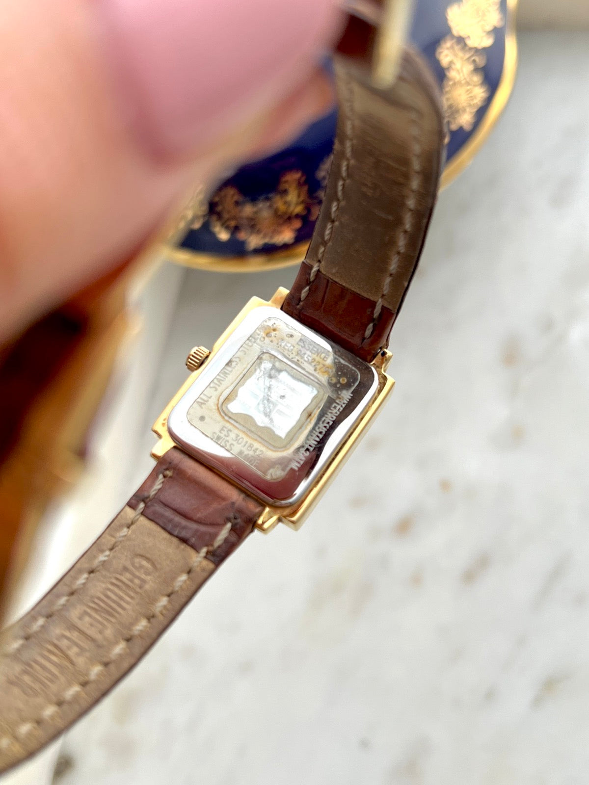 Givenchy watch caseback and underside of the brown leather strap