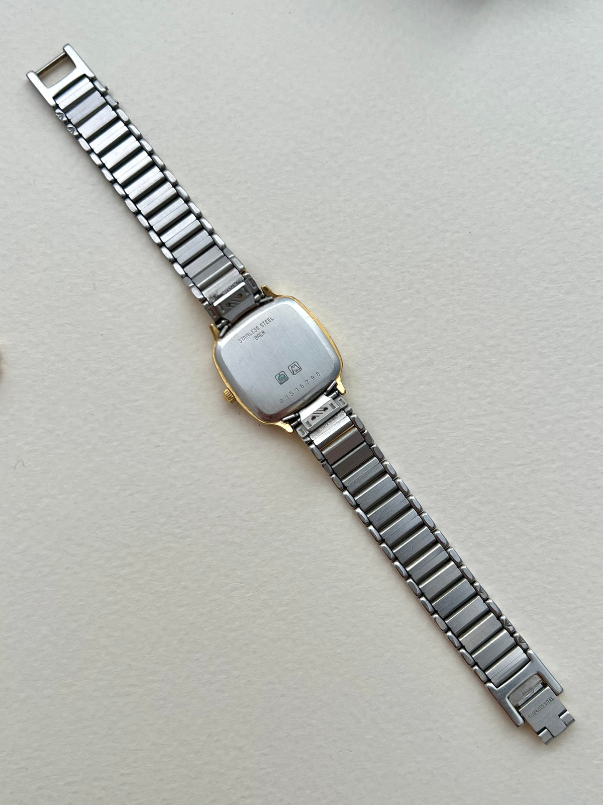 Full front view of the Longines soft-square ladies watch with gold-tone bracelet and pale textured dial.