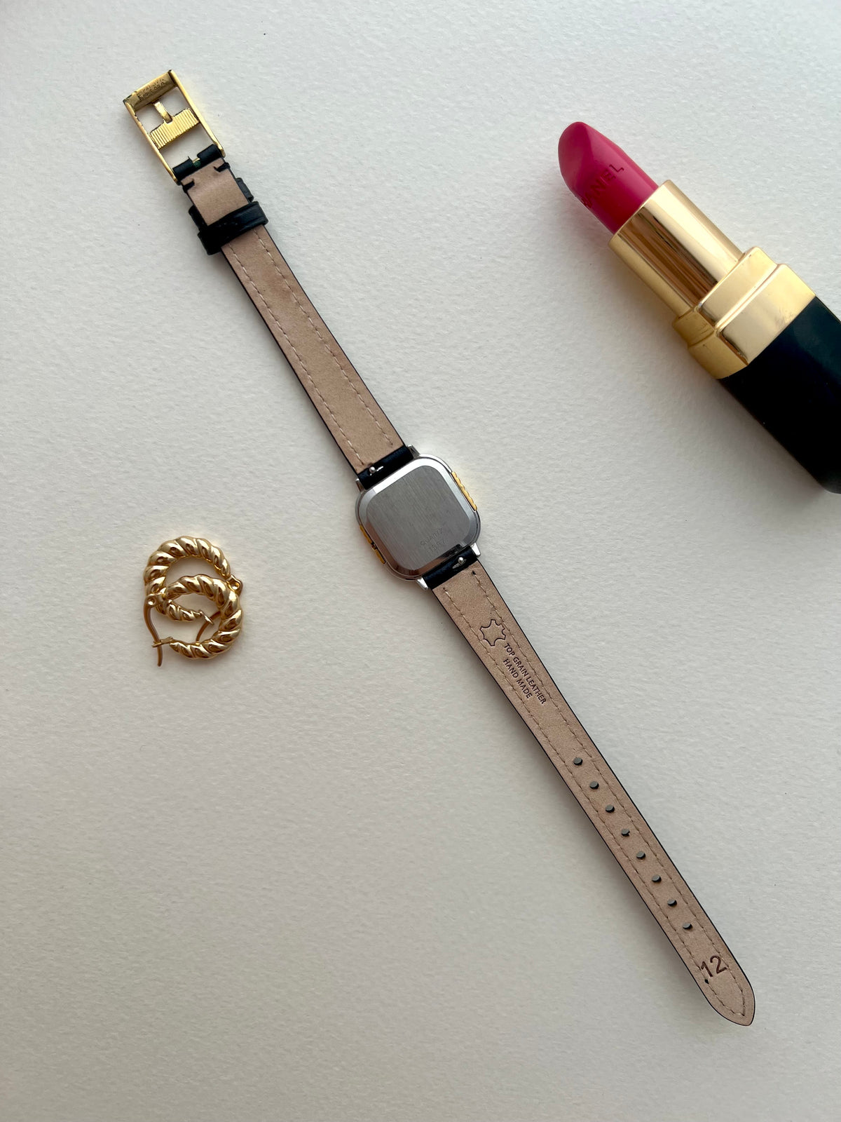 Side angle showing the raised twisted gold columns and soft-square Omega De Ville case.