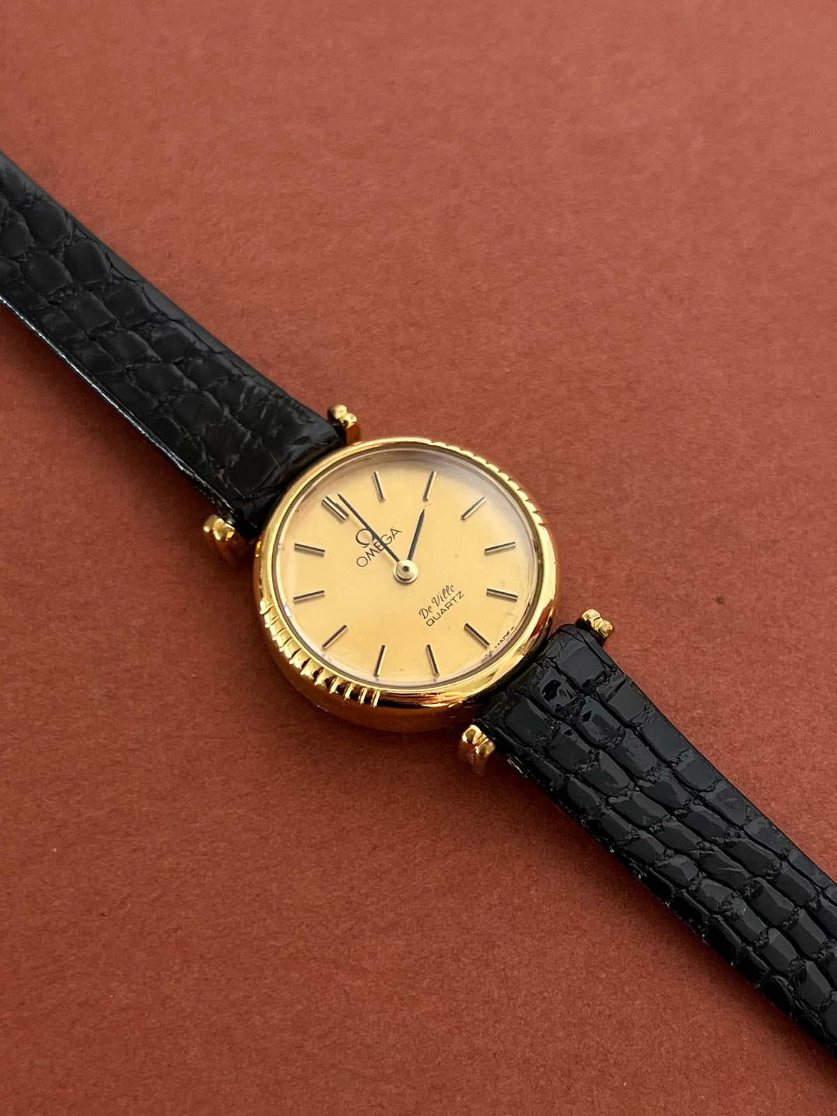 Omega De Ville gold-tone watch displayed with its included box.