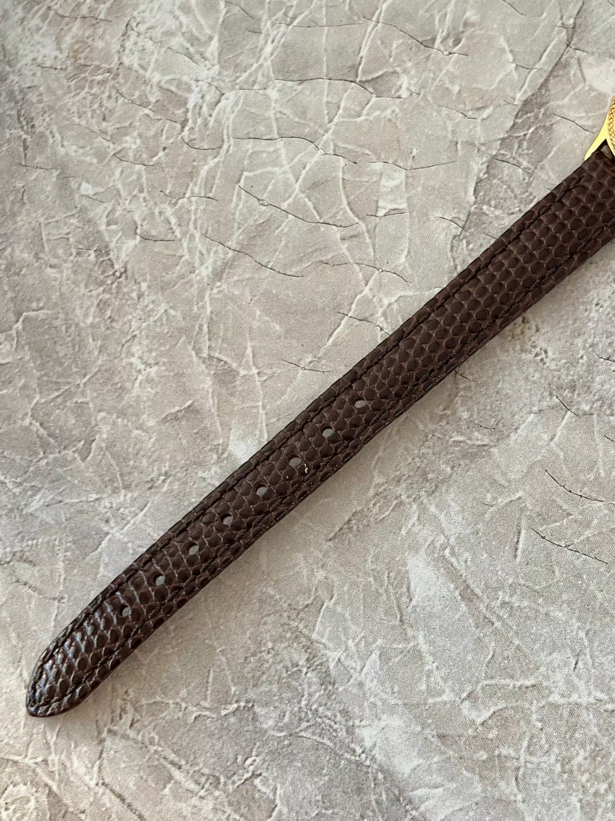 Omega De Ville Rope Bezel Brown Strap Watch: brown strap texture and adjustment holes.