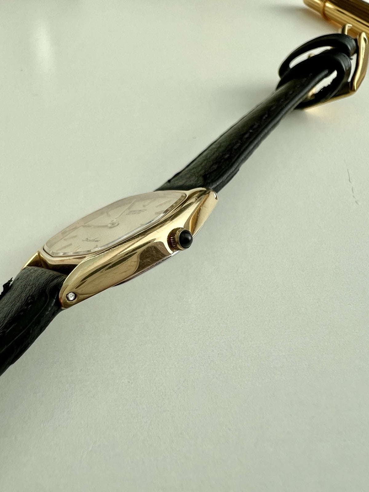 Side view of the Seiko Exceline showing its slim gold filled case, black stone crown and aftermarket leather strap.