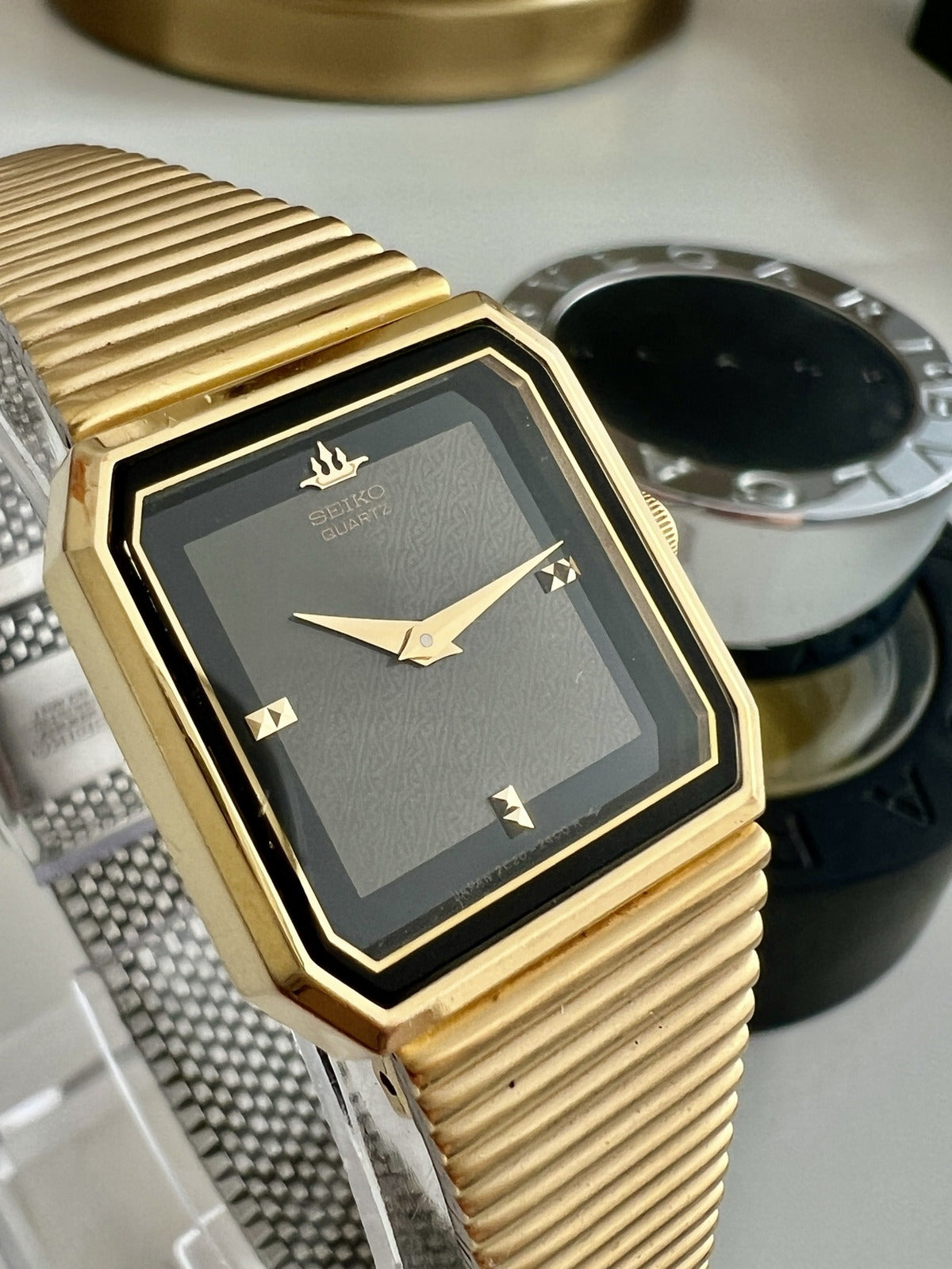 Close view of the Seiko Galaxy 2C20-6110 black textured dial, gold hands, faceted markers and angular case.