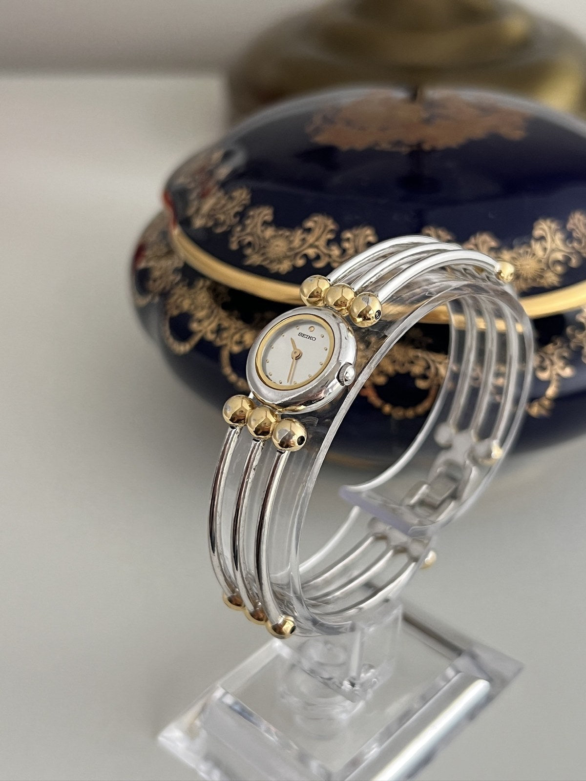 Side view of Seiko fixed bangle watch showing silver-tone strands and gold-tone bead details