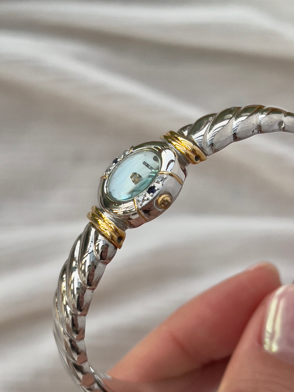 Seiko Bangle Woman's Watch – Two-Tone with Sapphire and Diamond Accents — close detail of the dial and band.