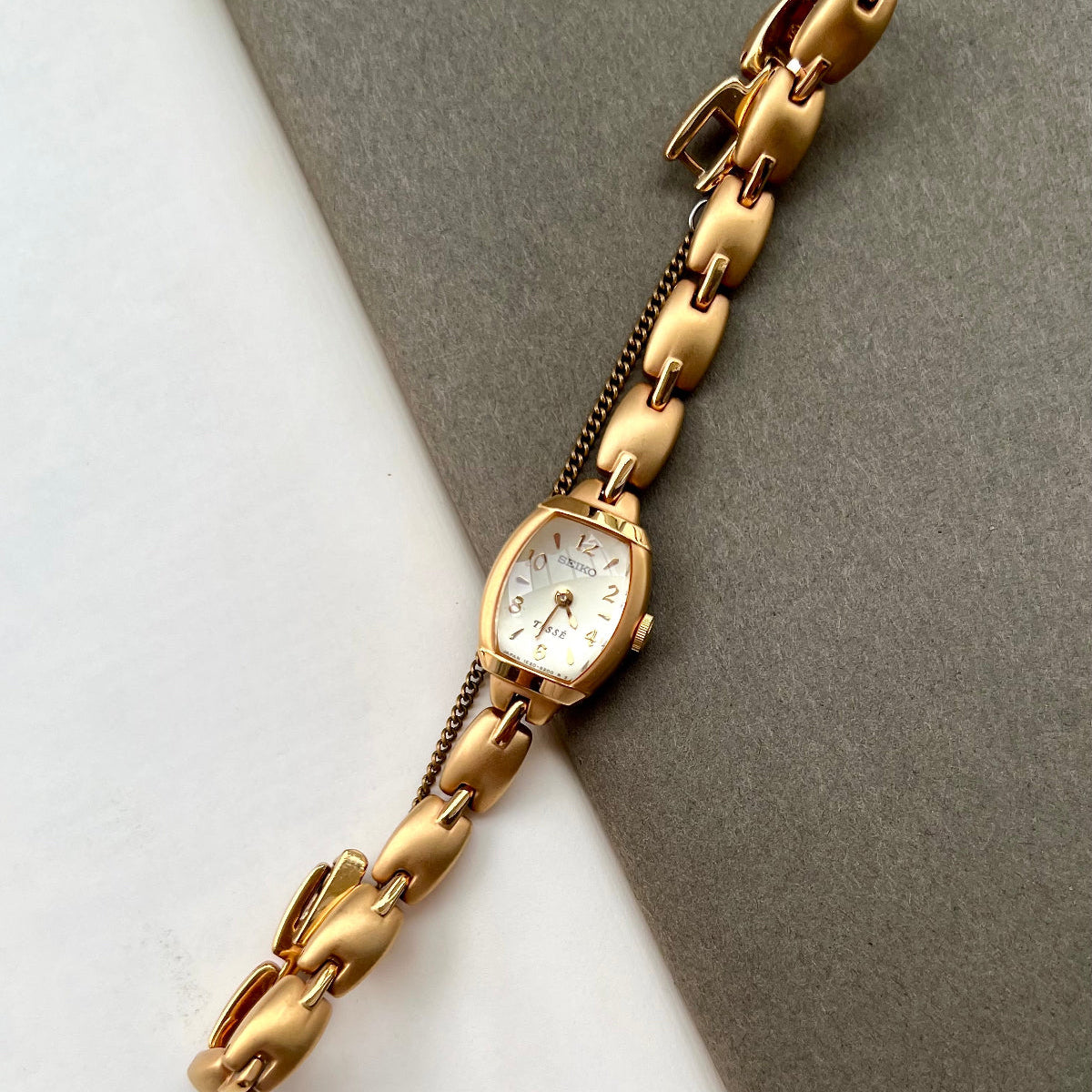 Seiko Tisse ladies gold bracelet watch with domed crystal and matte finish on neutral background
