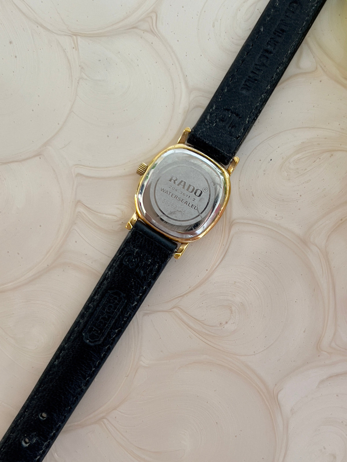 Rado Gold Cushion Women’s Watch with Fluted Case — 204.3611.2 caseback and leather strap underside.