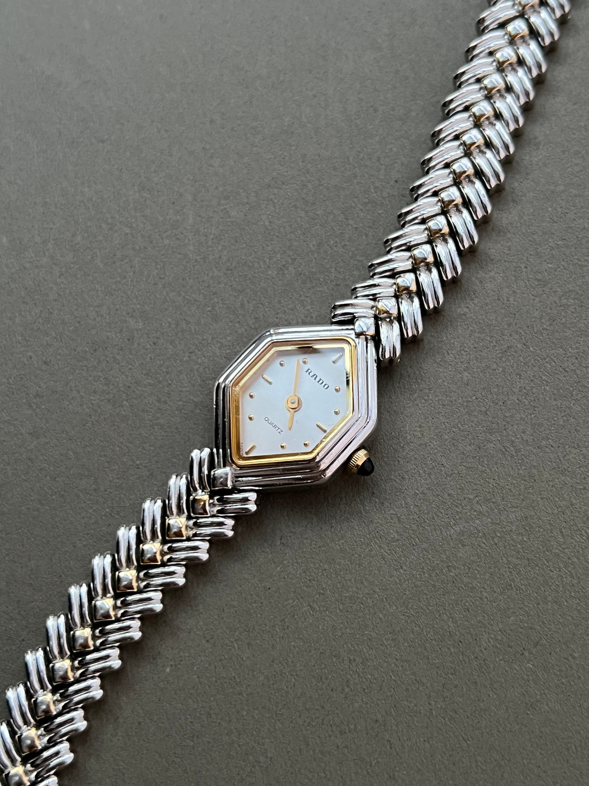 Vintage Rado two-tone sculpted women's watch with a pearl dial and herringbone bracelet, shown in an alternate angled front view.