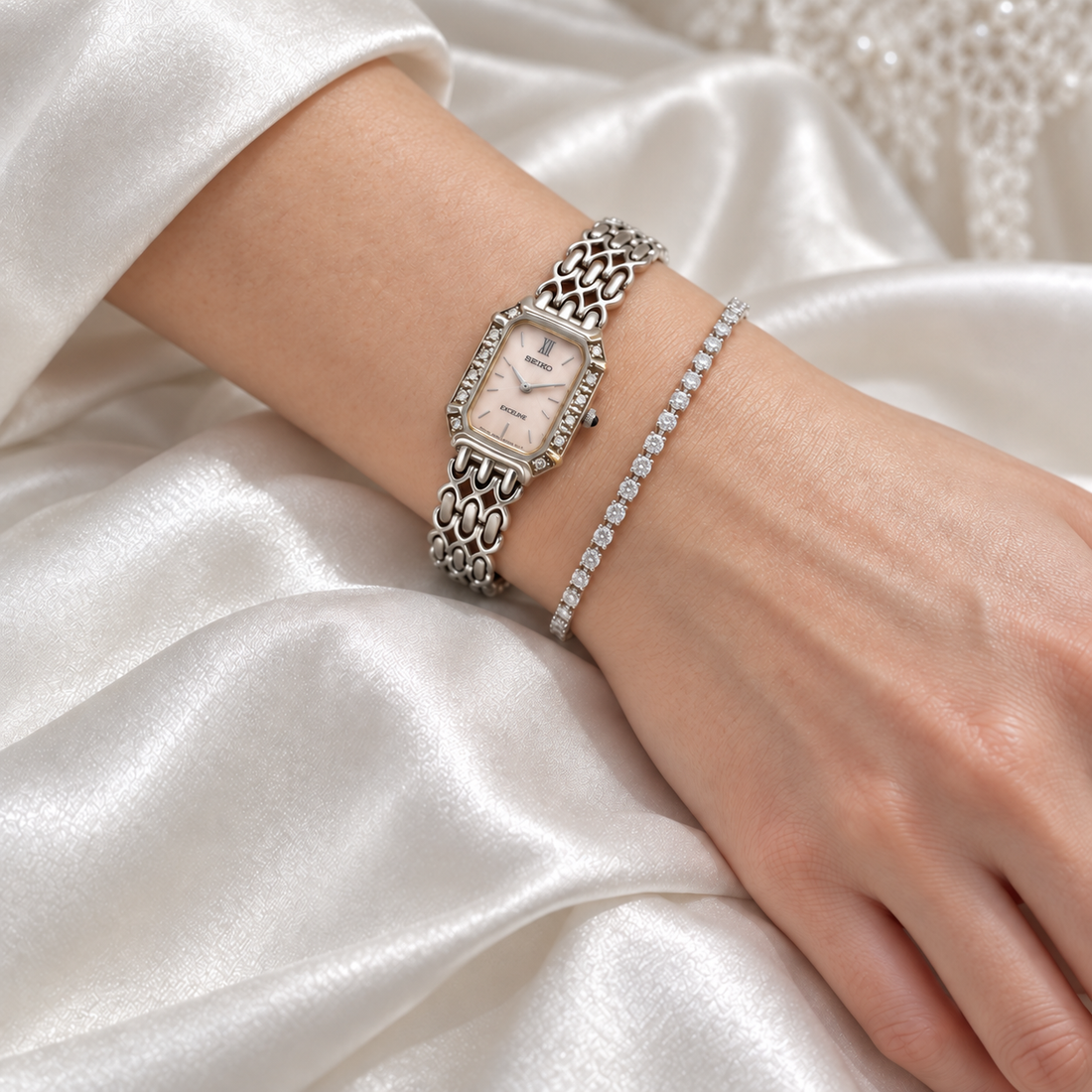 AI styling illustration of a silver Seiko Exceline watch worn with a tennis bracelet against ivory bridal satin