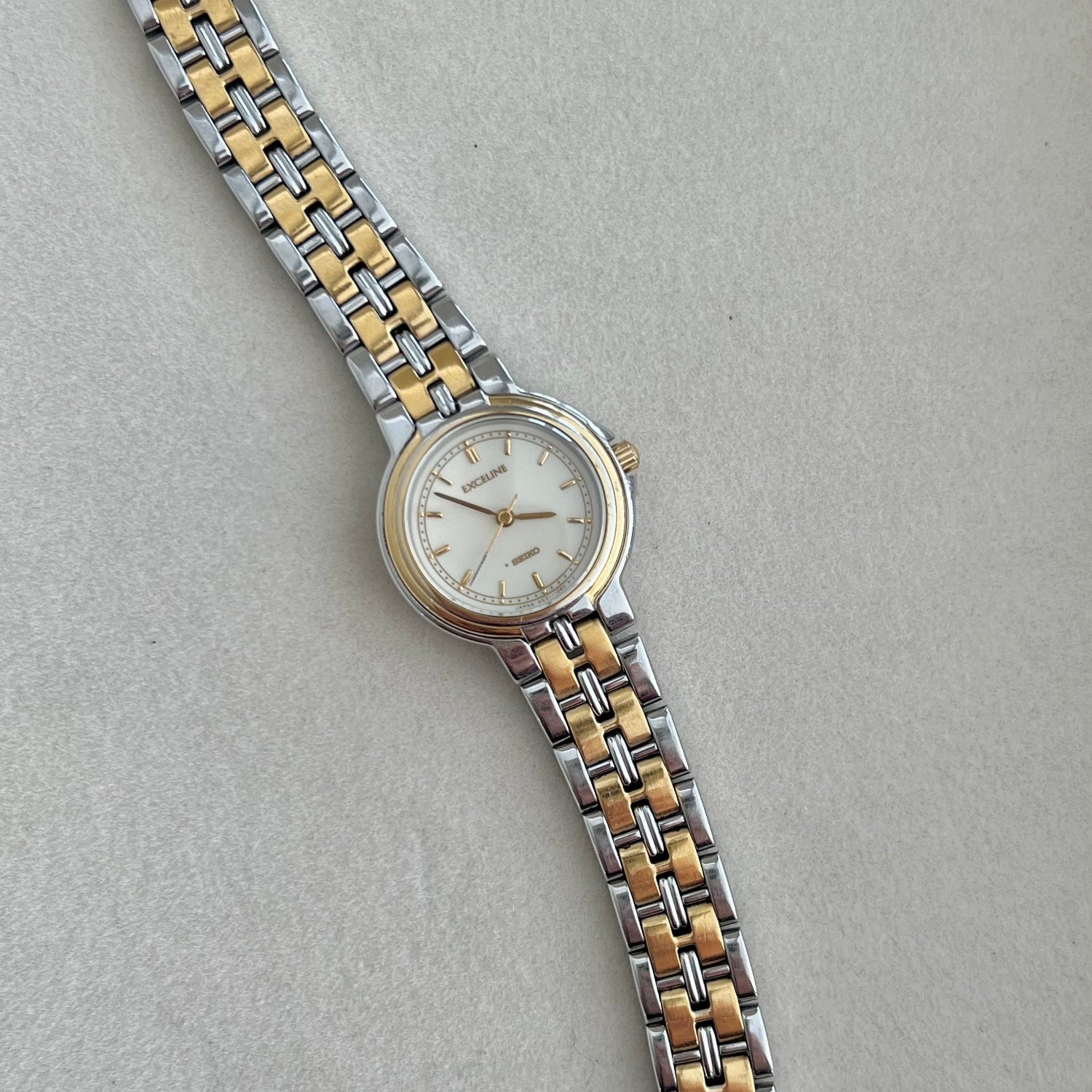 Two-tone watch with silver and gold band on a light gray background