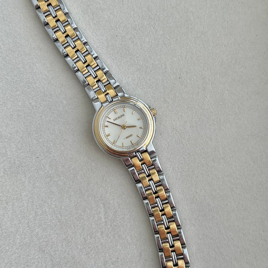 Two-tone watch with silver and gold band on a light gray background