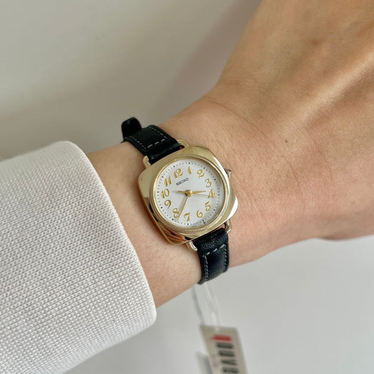 Seiko Nouveau Gold White Cushion Strap Watch: watch worn on a wrist.