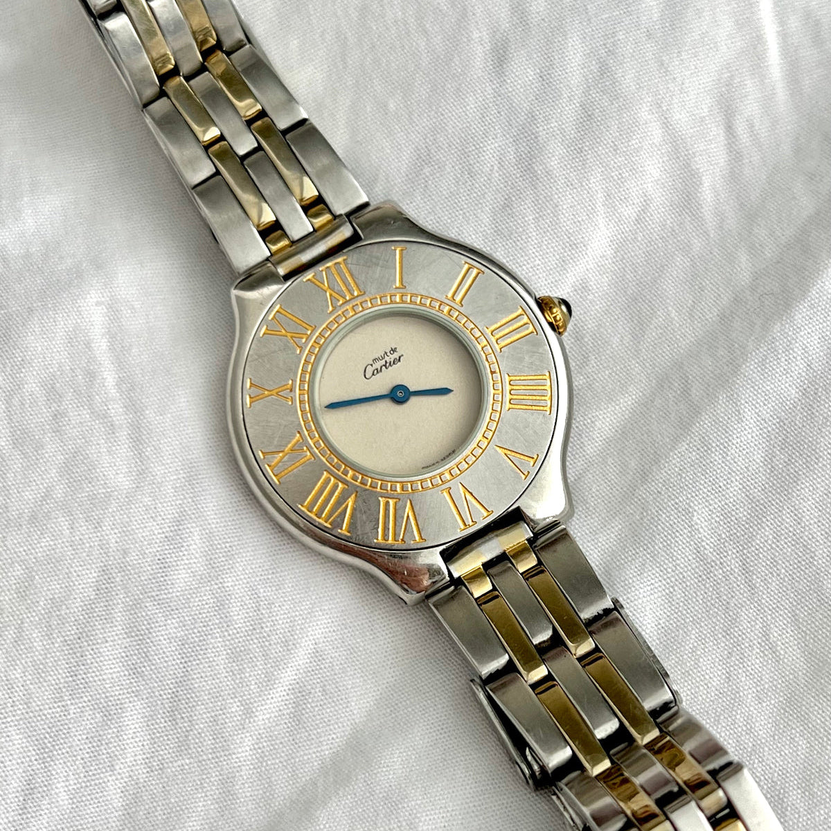 Cartier 21 Two-tone watch with silver and gold band on a white fabric background