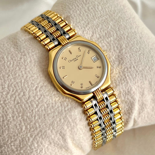 Christian Dior Gold and silver watch on a textured surface