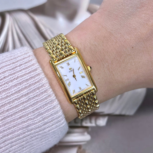 Gold Citizen Noblia Tank wristwatch on a person's wrist with a blurred background