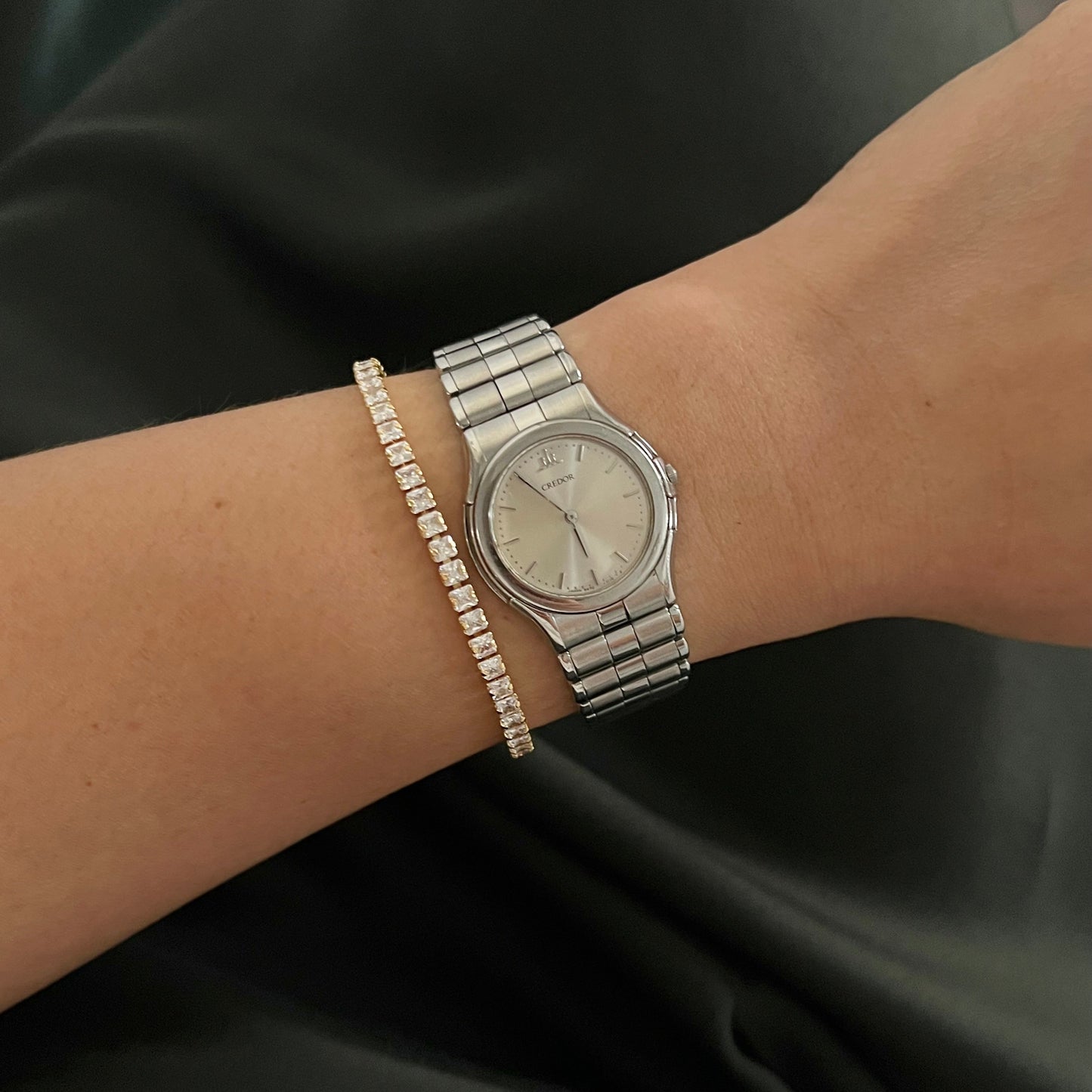 Silver Credor Ladies watch on a wrist with a black background