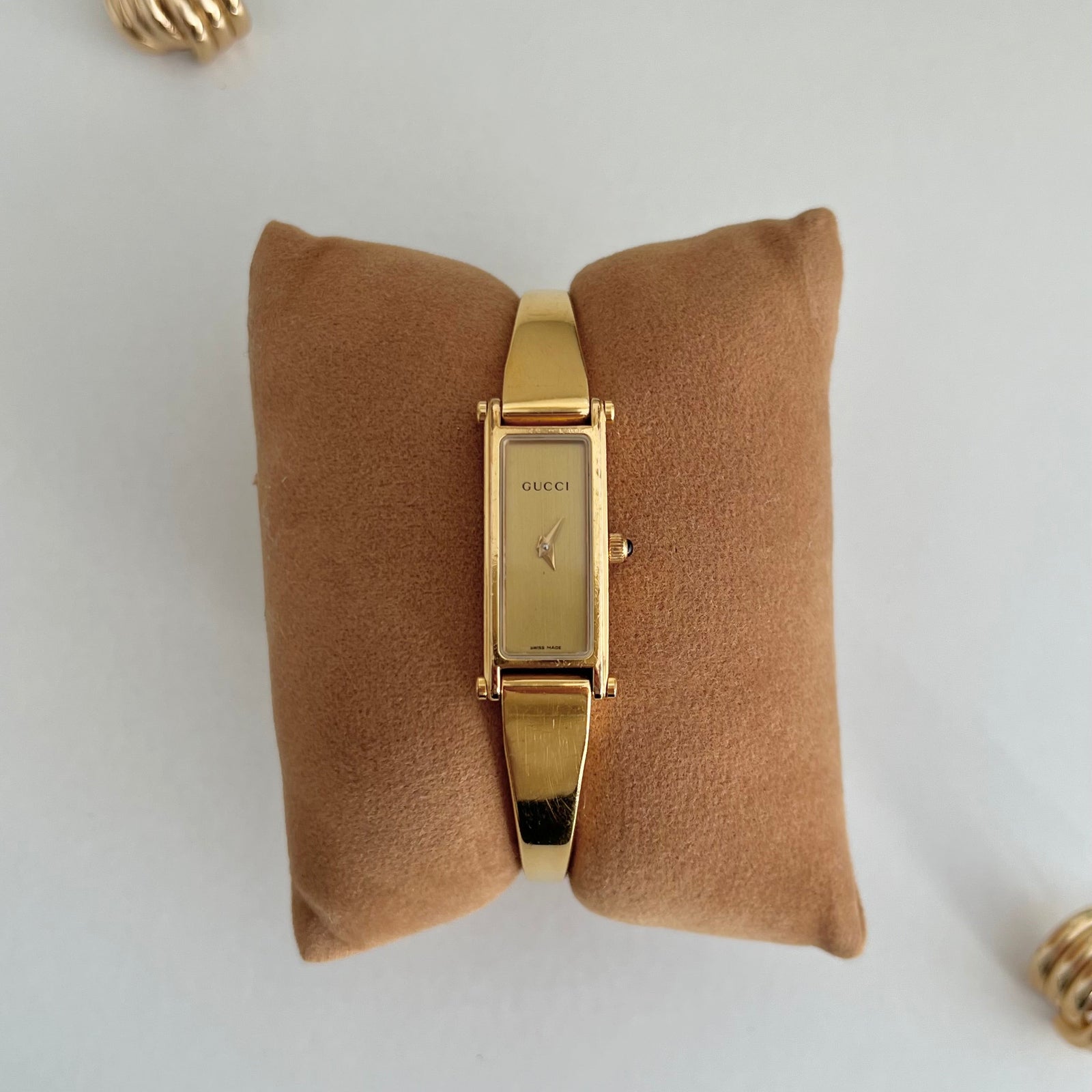 Gold tone Gucci 1500L women’s bangle watch with a slender champagne dial