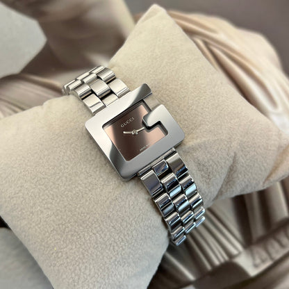 Silver Gucci 3600L watch on a beige cushion
