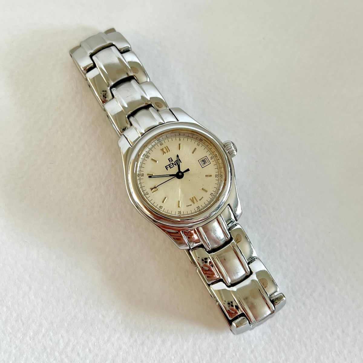 Silver Fendi women's watch with a white face on a light gray background