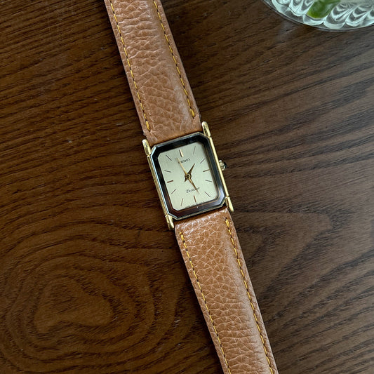 Vintage Seiko Tank Women's watch with brown leather strap on a wooden surface