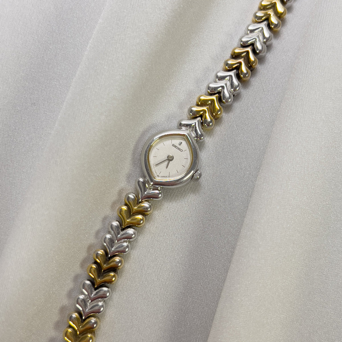 Seiko petite ladies watch Wristwatch with a decorative metal band on a white fabric background