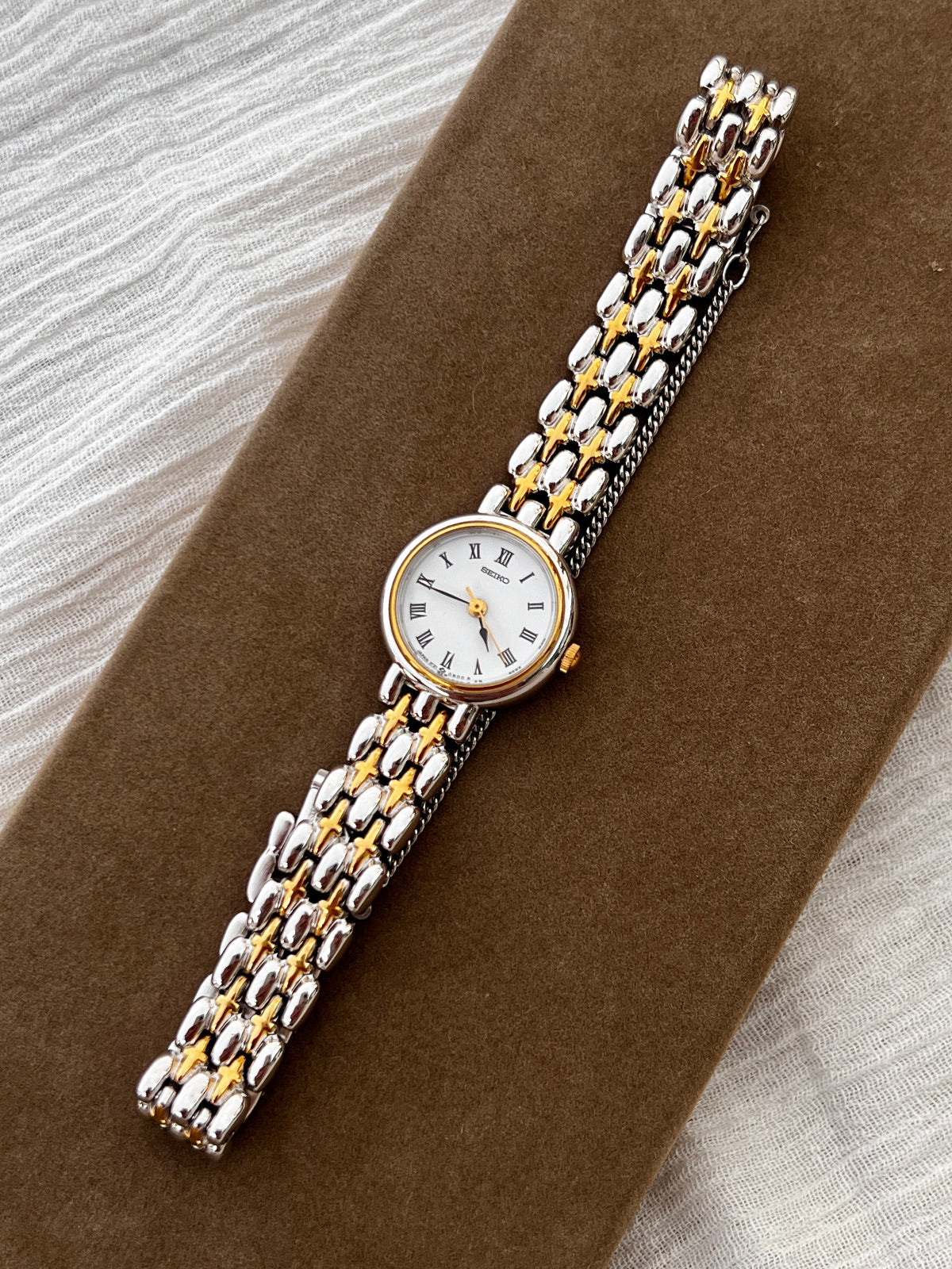 Seiko vintage ladies dress watch with two-tone gold and silver bracelet, white Roman numeral dial, and spade hands – classic quartz timepiece from Gilded Hour NZ.
