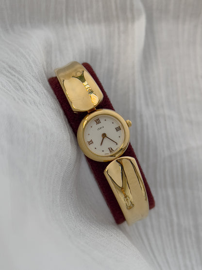 Vintage Citizen Chère women’s gold bangle watch with white dial and Roman numeral, styled on wrist with a crystal tennis bracelet
