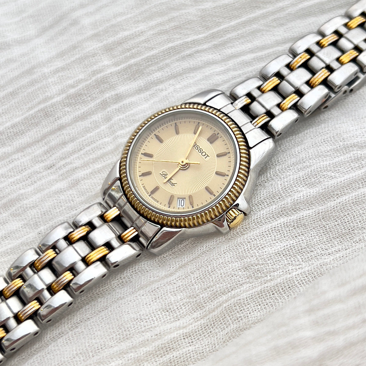 Two-tone watch with silver and gold band on a light gray background