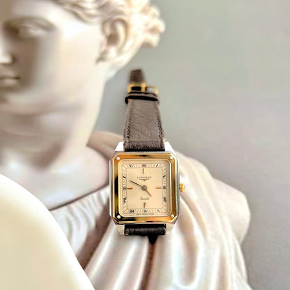 Longines Two Tone Gold watch with a gray strap on a classical statue