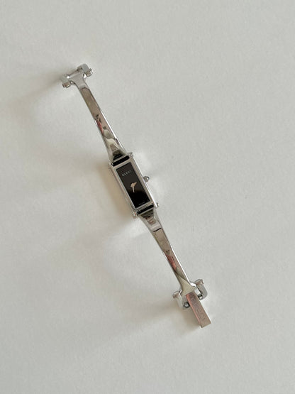 Gucci 1500L Silver Bangle Women's Watch Black Dial, angled view of a vintage women's watch at Gilded Hour.