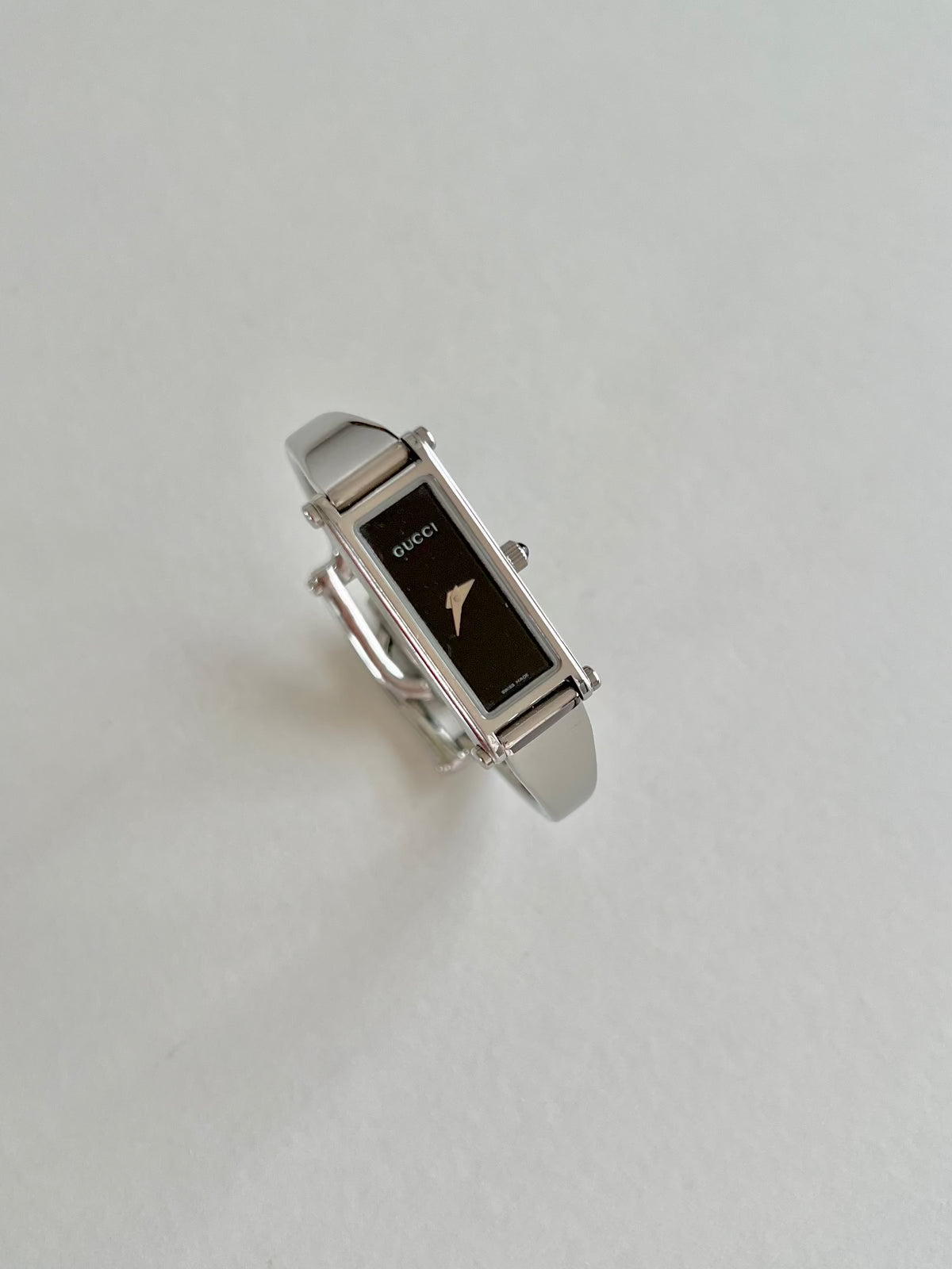 Gucci 1500L Silver Bangle Women's Watch Black Dial (Small), angled view of a vintage women's watch at Gilded Hour.