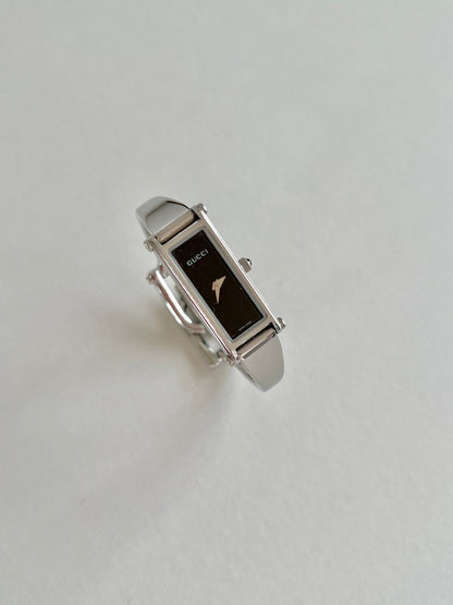 Gucci 1500L Silver Bangle Women's Watch Black Dial (Small), angled view of a vintage women's watch at Gilded Hour.