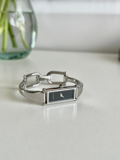 Gucci 1500L Silver Bangle Women's Watch Black Dial (Small), wrist shot of a vintage women's watch at Gilded Hour.