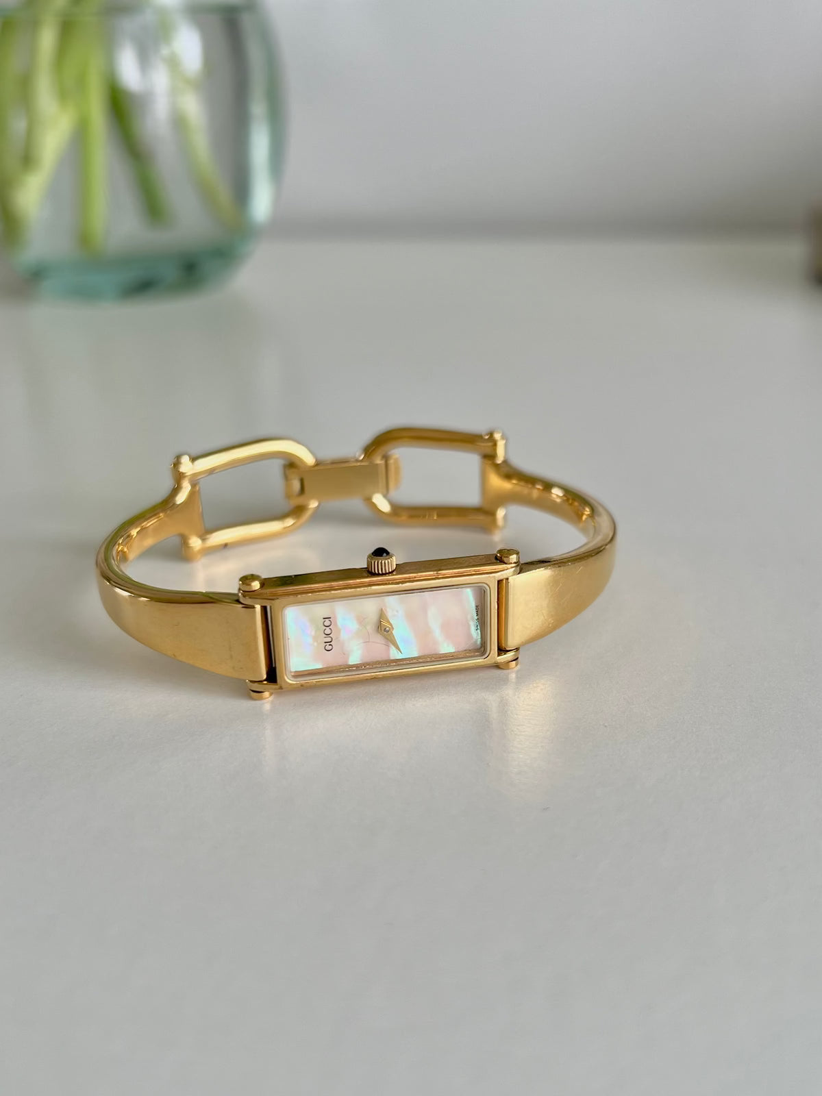 Gucci 1500 Gold Bangle Women’s Watch Mother of Pearl Dial, angled view of a vintage women's watch at Gilded Hour.