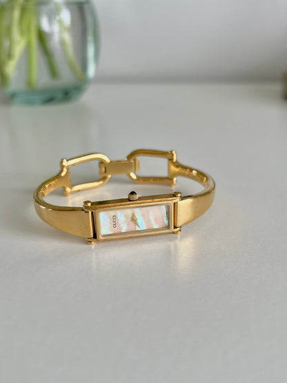 Gucci 1500 Gold Bangle Women’s Watch Mother of Pearl Dial, angled view of a vintage women's watch at Gilded Hour.
