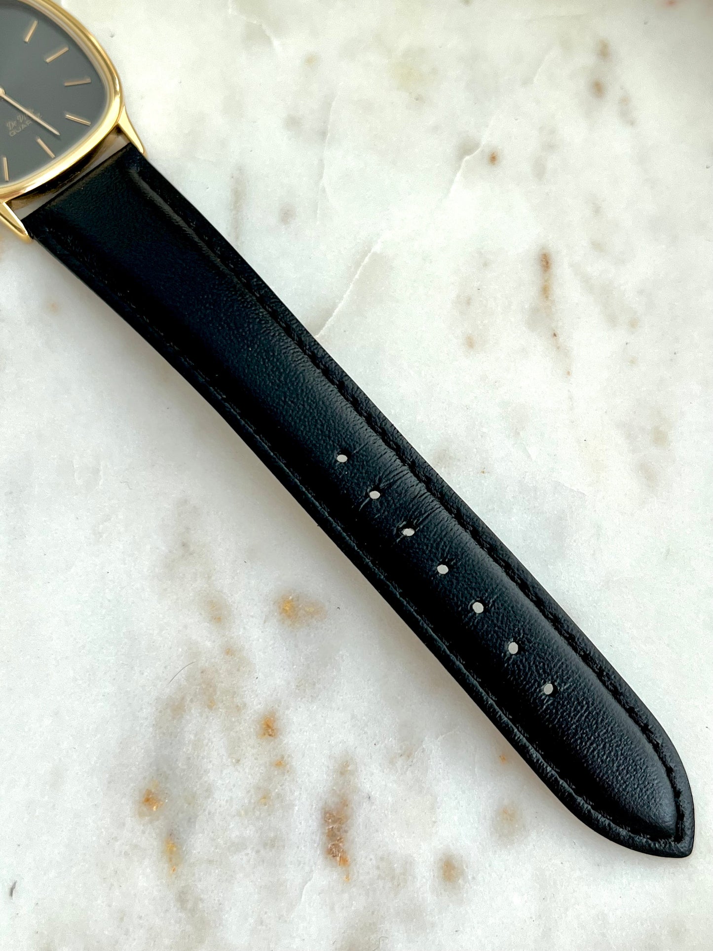 Black watch strap on a marble surface
