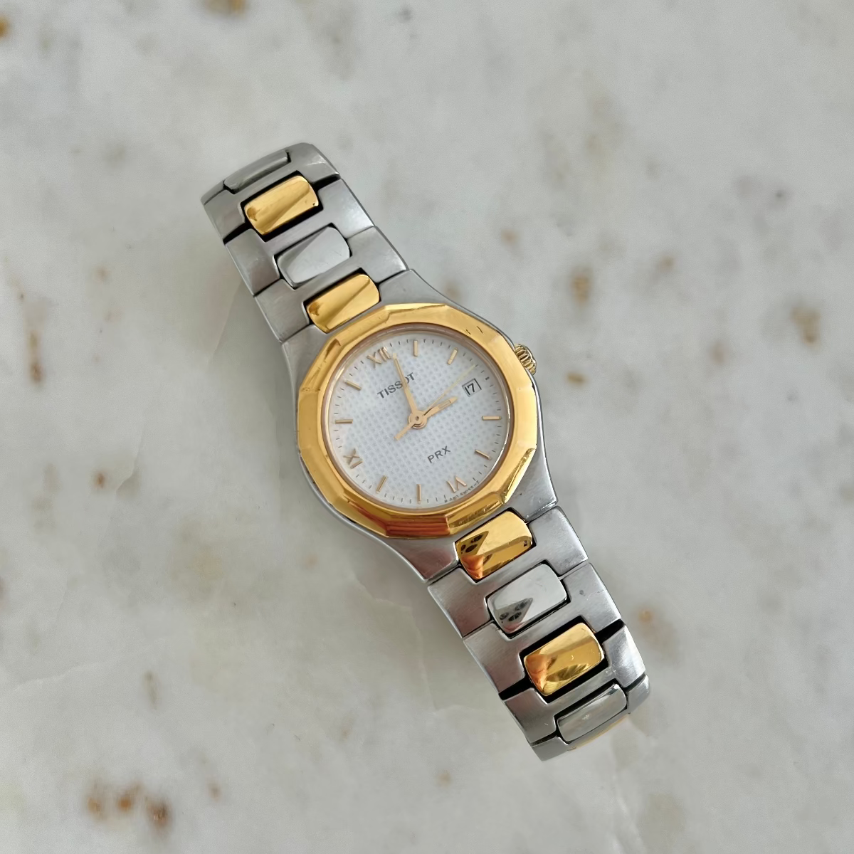 Tissot P440 White Roman Date Two Tone Watch: full integrated bracelet laid flat.