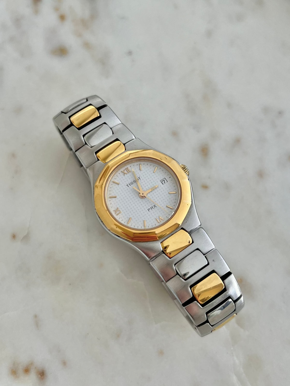 Tissot P440 White Roman Date Two Tone Watch: angled faceted bezel and patterned dial.