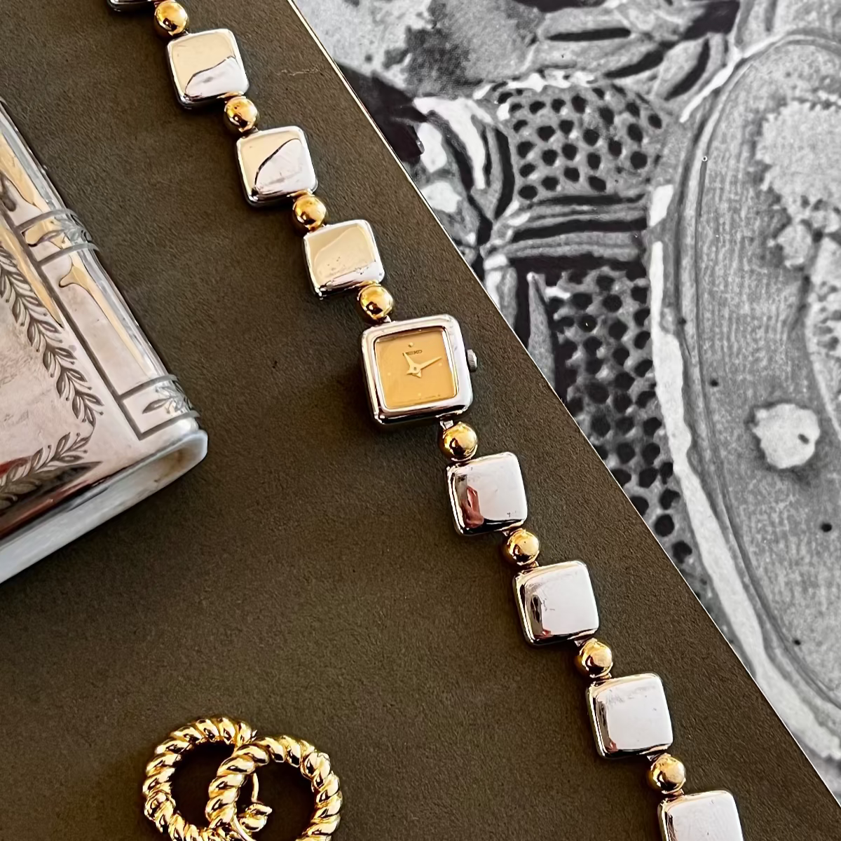 Seiko gold and silver bracelet with matching ring on a textured surface